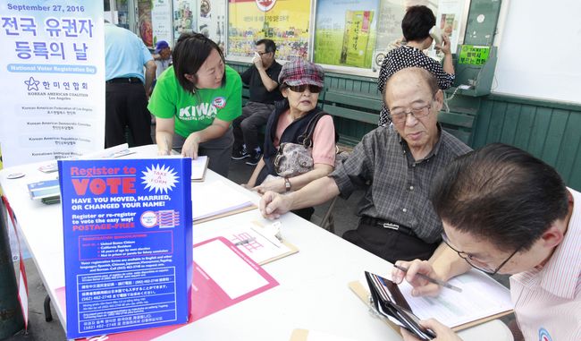 Nonprofit organizations in Koreatown held campaigns on Tuesday to help more Korean-Americans become registered voters. Koreatown Immigrant Workers Alliance manager Seung-hye Seo (on the far left) is helping Ja-hoon and Kyung-ja Kim register to vote alongside K.W. Lee Center for Leadership manager Do-hyung Kim Kim (on the far right). Sang Jin Kim 