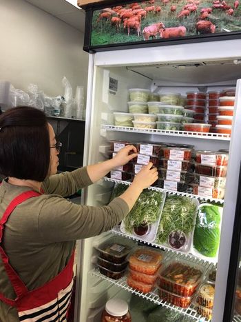 Meat shops in Koreatown are seeking better sales by increasing the number of non-meat items at their businesses. Shin Sun Meat owner Keum-sook Joo is organizing the side dish items at her shop. 