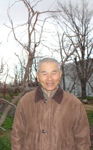 Cheon-su Ahn posing in front of a red date tree.